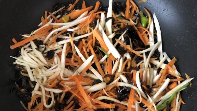 超过瘾的鱼香肉丝,再倒少许油把胡萝卜丝、杏鲍菇丝、木耳丝炒至断生。