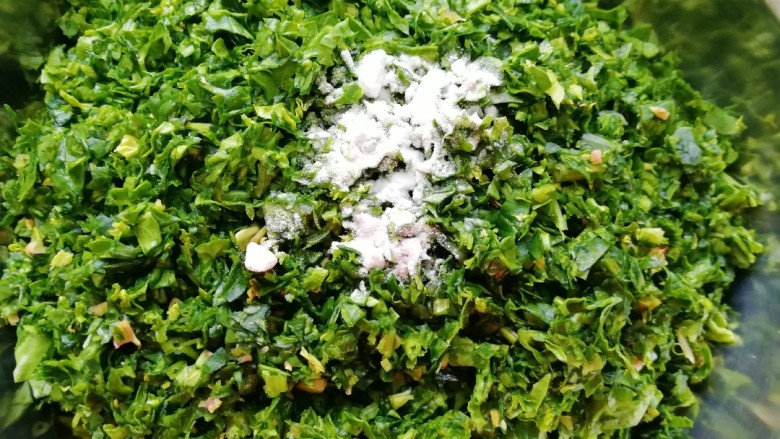 玉米面菠菜菜团,剁好的菠菜放在盆里,加入食用碱搅拌均匀(放食用碱的目的是为了让蒸好的菠菜菜团不发黄,介意的可以不加,不影响口感)。