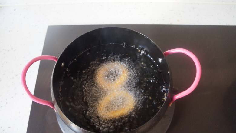 香酥鱿鱼圈,锅中倒油烧到5成热,放入处理好的鱿鱼圈,中火炸定型,再转小火炸到金黄色即可。