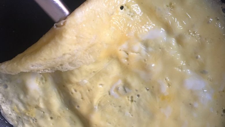 咖喱蛋包饭,8️⃣ 小火煎至表面刚好凝固(如果想做成半圆状,这个时候可以倒入剩饭,然后卷起一边盖上即可),关火。用余温热至蛋皮完全凝固。