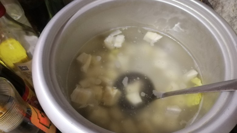 粉葛鲮鱼汤,汤锅中放水,开火,放入生姜,把粉葛从清水中捞起放入汤锅,盖上盖子煲。