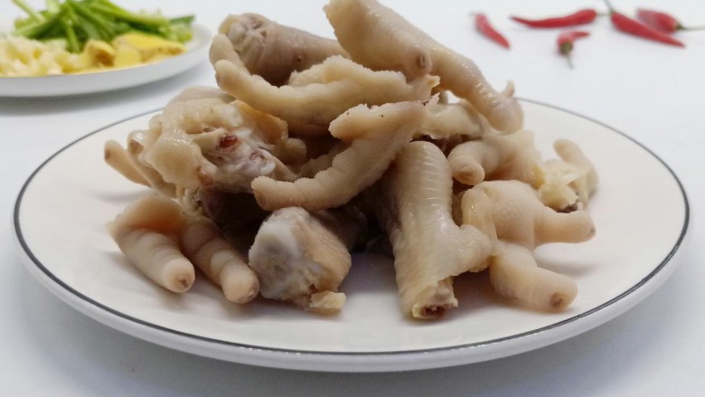 下酒小菜《香辣红烧鸡爪》,用砍骨刀对半切开,便于入味。