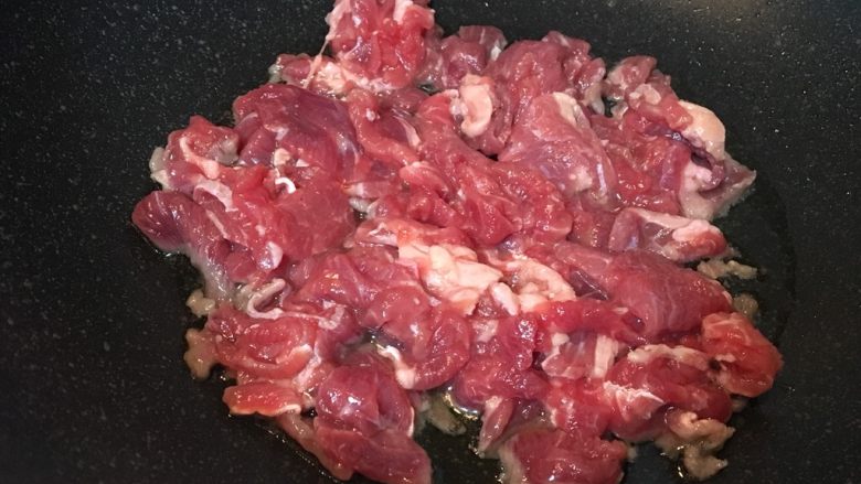 大蒜牛肉片,放入牛肉片,快速大火翻炒。