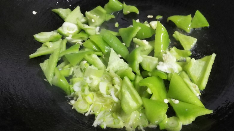 素鸡豆腐炒青椒,锃内放少许油烧热,放入葱片、青椒大火煸炒。