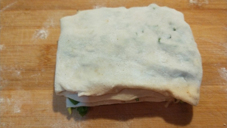 新文美食 葱油饼,叠好的在用擀面杖擀成见方饼。