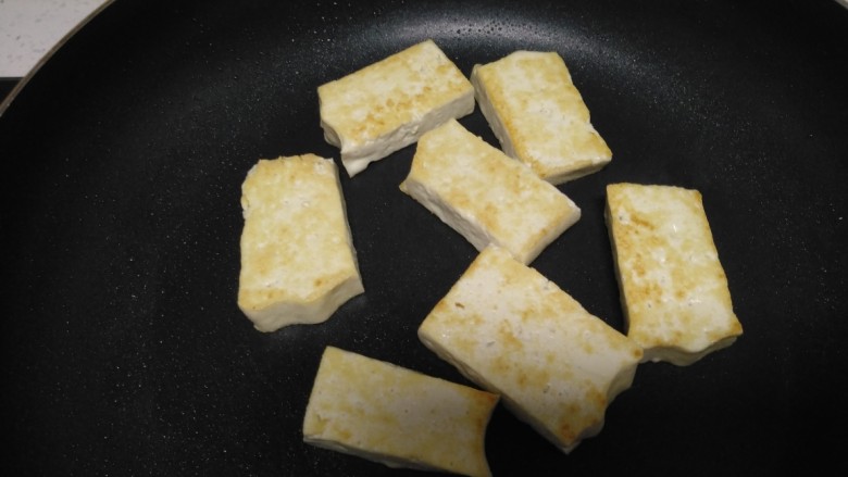 豆腐炒杂蔬,不粘锅中放入少量油,将豆腐煎至两面金黄。