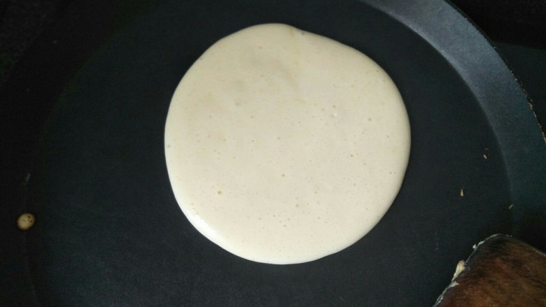 蛋糕饼,平底锅烧热转慢火放入适量蛋糕糊,煎到表面有很多小泡泡翻转过来煎另一面。