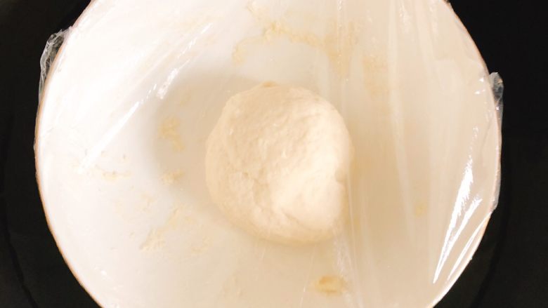 芝士培根披萨,包上保鲜膜,放入装有温水的锅里发酵至2倍大,大约1小时,中间需加热1次锅里的水,因为时间久了会凉。