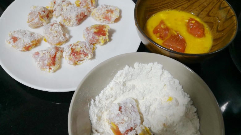 菠萝咕咾肉炒年糕,先将肉块在鸡蛋液中浸没,取出放在面粉里打个滚,放一旁静置五分钟。