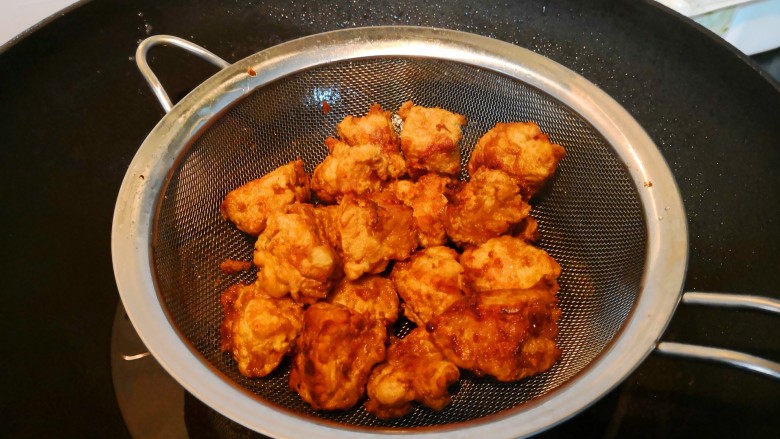 菠萝咕咾肉炒年糕,捞起肉块沥油。