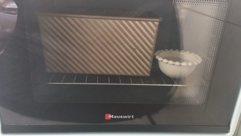 抹茶吐司,烤箱启动发酵键,烤箱内放碗热水,将模具放入烤箱内二次发酵