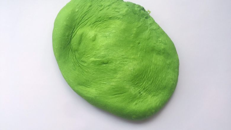抹茶吐司,将面团取出,倒在揉面垫上,用手掌轻轻按压排气