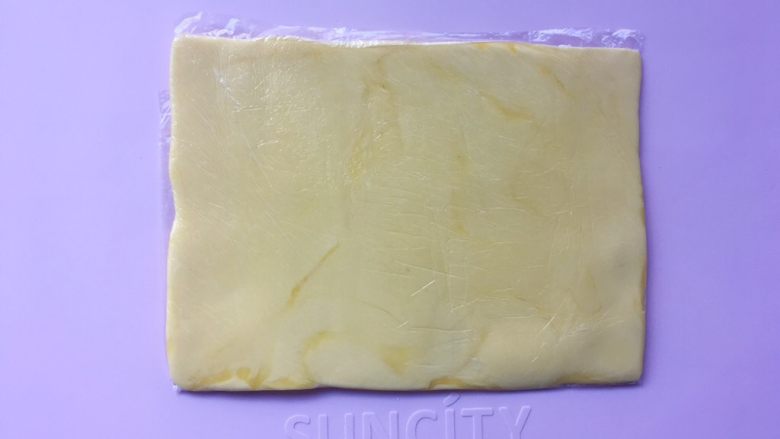 可颂热狗,之后对折保鲜袋,将黄油用擀面杖擀成均匀厚度的黄油片,之后入冰箱冷冻10分钟将黄片冻硬