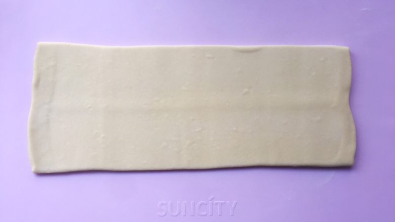 可颂热狗,揉面垫上撒点干粉,将包裹好的面片收口朝下,用擀面杖轻轻擀成长条