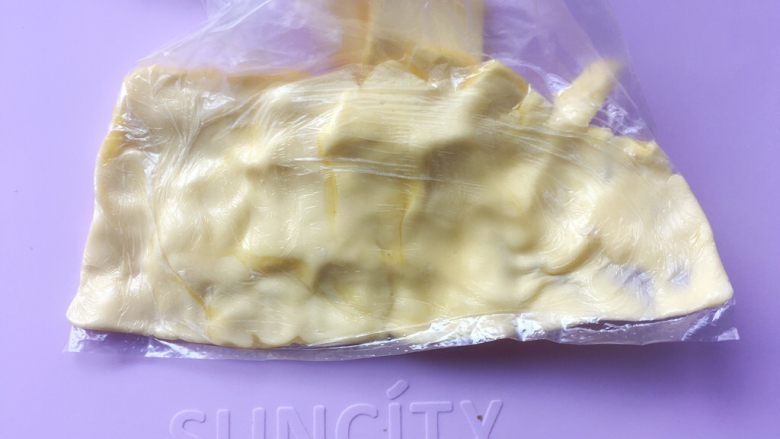 可颂热狗,将裹酥用黄油切薄片装入小号保鲜袋内,先用手捏软底部的黄油,将黄油捏满保鲜袋的两个角