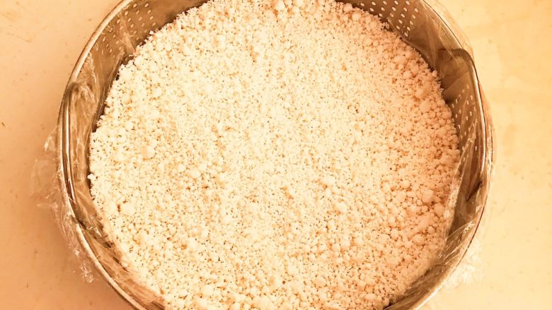 自制年糕,在蒸笼里面放入1.5㎝厚的潮湿糯米粉,铺匀