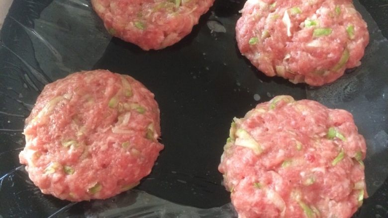 西葫芦肉饼,带上干净的手套,将拌好的肉末搓成圆球,再按压成饼;