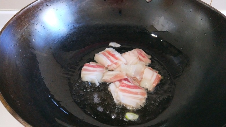 新文美食 五花肉炒荷兰豆,锅中倒入适量油烧热,放入五花肉煸炒。