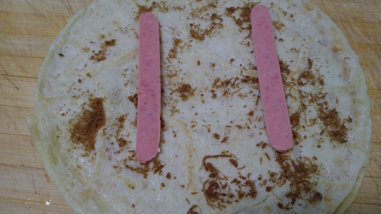 早餐肉松蛋饼,盛出,均匀撒上肉松,<a style='color:red;display:inline-block;' href='/shicai/ 438'>火腿</a>一分为二放上。