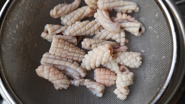 海鲜疙瘩汤,将鱿鱼也过水焯熟,水一开,下鱿鱼板,关火,鱿鱼打卷沥水捞出即可。
