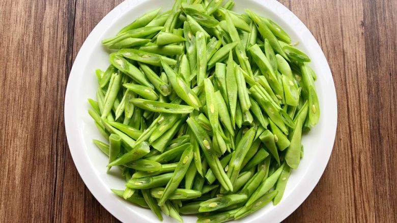 家常豆角焖面,豆角掐掉头尾,清洗干净,切成斜块(这样方便入味),放入盘里待用。