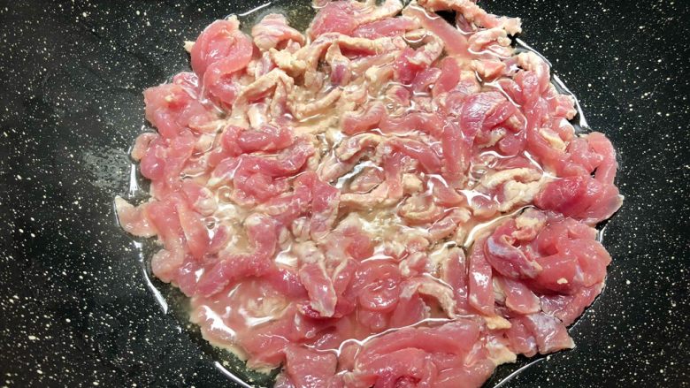 家常豆角焖面,热锅放入适量油,放入肉丝煸炒。