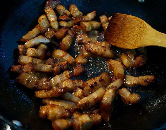 红烧肉炖鹌鹑蛋,将五花肉块倒入中小火翻炒,将肉块中的油脂煸出来直至再也不出油为主(煸出的油倒出炒别的菜用);
