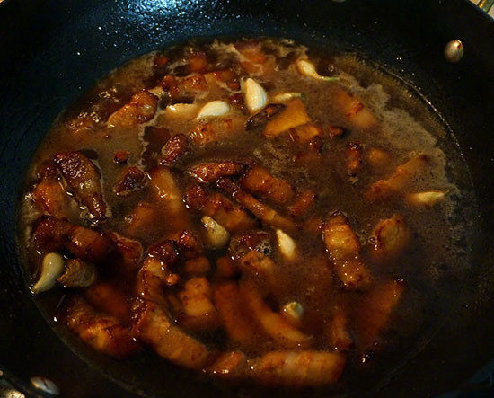红烧肉炖鹌鹑蛋,沿着锅边倒入与肉持平的热水(不要倒在肉块上,这样焦糖色就能很好地保留在肉块表面了),也不要翻动肉块,盖上盖子,小火焖烧20分钟;