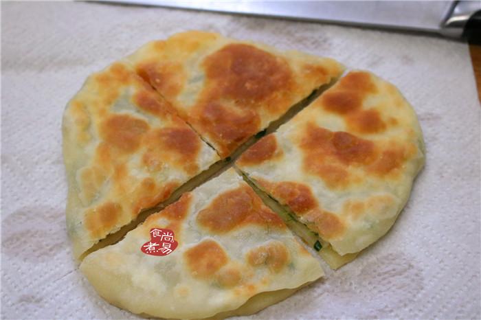 香葱煎肉饼,将煎好的馅饼取出,用吸油纸吸去多余的油分,切块摆盆即成。