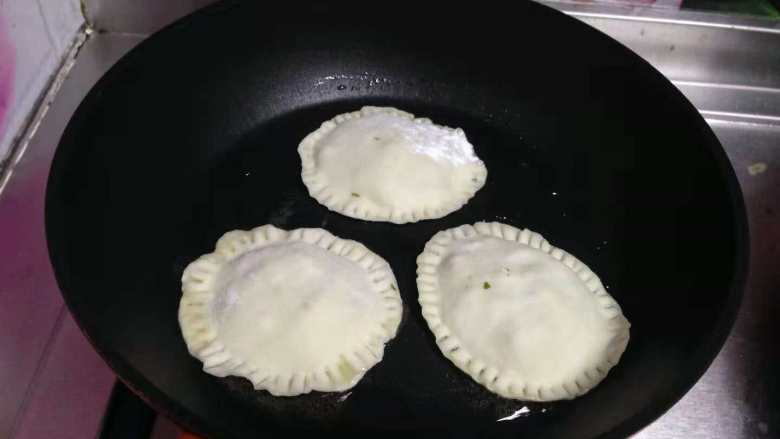 饺子皮版芹菜盒子,
不粘锅加少许油，小火放入饼坯