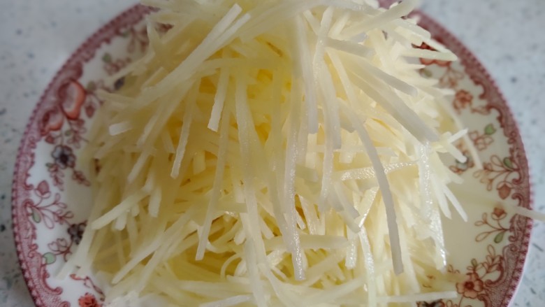 酸辣土豆丝,将土豆切丝,用凉水洗干净,装盘备用。