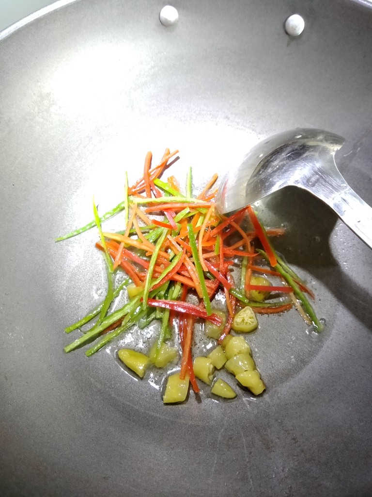 酸辣土豆丝,锅中倒入少许色拉油,加入泡椒,青红尖椒,滑炒下。