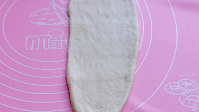 中种豆沙吐司面包,取一块面团,用擀面杖擀开,将气泡拍破。