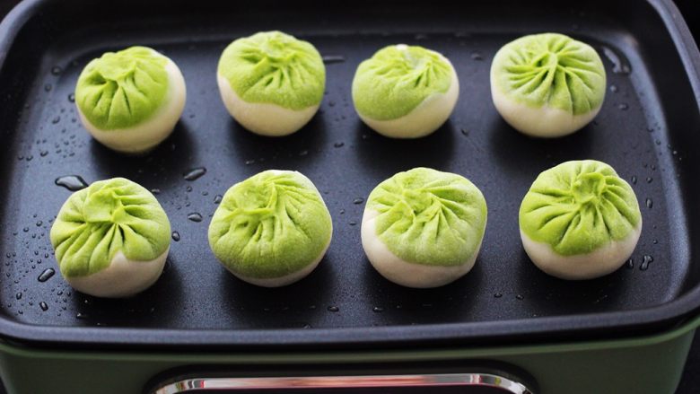 翡翠白玉生煎包,锅中用刷子蘸少许食用油,涂抹一下锅底,锅热后放入包子。