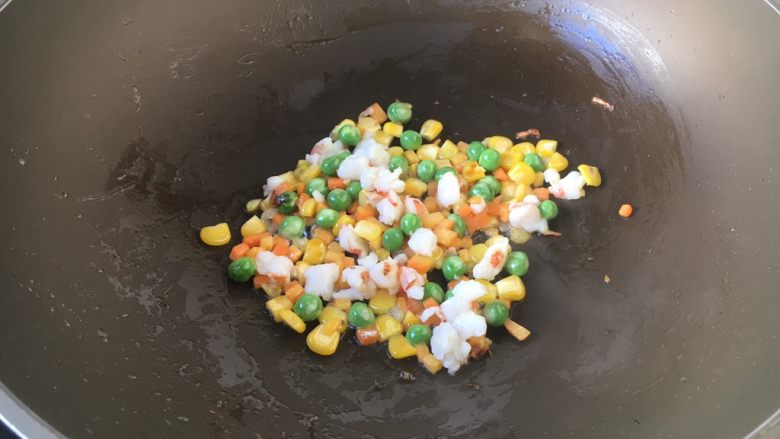 芝士焗番茄鲜虾米饭盅,然后放入鲜虾粒,翻炒几下(15秒左右)至鲜虾变粉色。