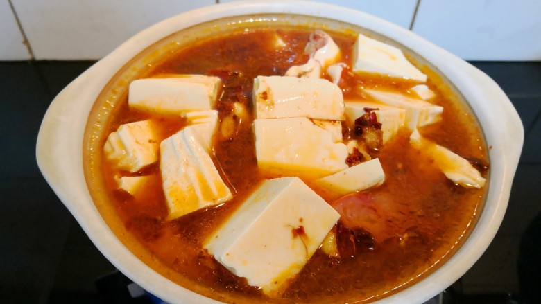 鲶鱼豆腐煲,将煮开的豆瓣酱汤汁倒入砂锅,开大火加盖煮。
