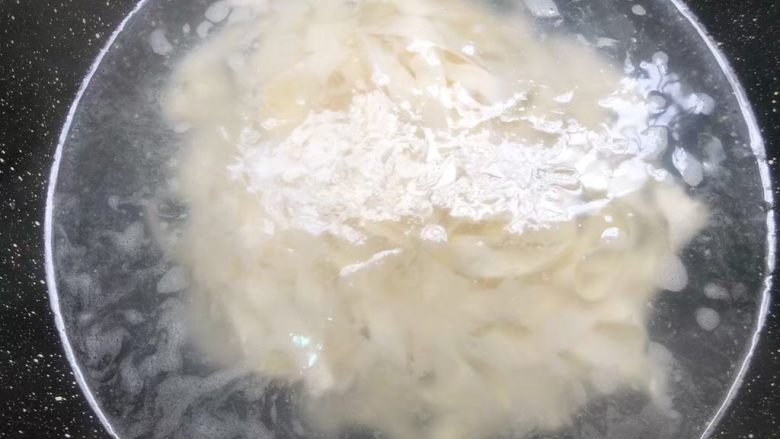 酸汤面,锅里放入半锅水烧开,放入面条煮至浮起来,把面条捞起来,倒入凉开水里过凉,过凉以后,把面条捞起来,放入辣椒油的碗里。