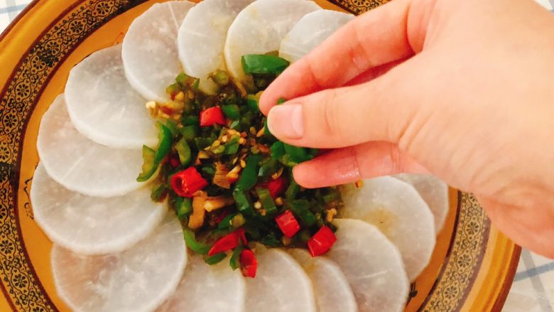 清蒸白萝卜-下饭菜,将炒好的酱料装到蒸好的萝卜盘子里,撒上葱花,完成。