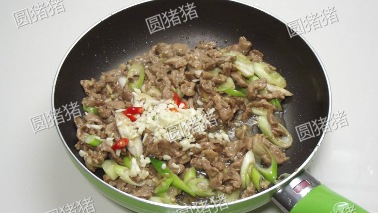 葱爆羊肉,继续大火爆炒约30秒,加入蒜碎及红椒片。