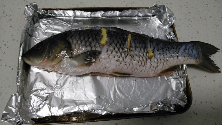 烤鱼,鱼从冰箱拿出解冻后，鱼身两面均匀抹盐，然后在鱼身两面各划3刀，塞上<a style='color:red;display:inline-block;' href='/shicai/ 37'>姜</a>片，鱼肚里塞入<a style='color:red;display:inline-block;' href='/shicai/ 3250'>葱</a>。