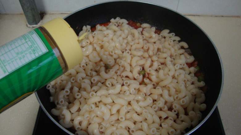 茄汁培根焗水管面,倒入酱汁中，撒芝士粉炒匀