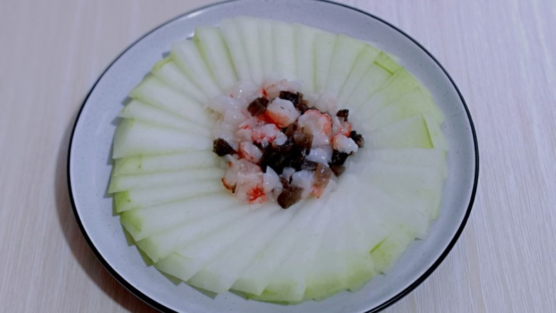 虾蓉蒸冬瓜,将腌制好的虾蓉及海参放在冬瓜盘的中间,如图。