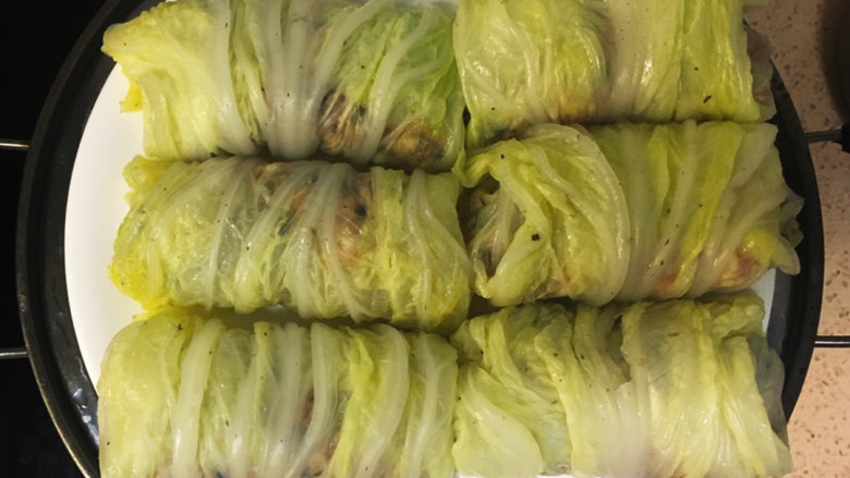 金玉白菜卷,包好的白菜卷放蒸锅上大火烧开后继续蒸20分钟左右,蒸好后盆中多出的水倒出备
