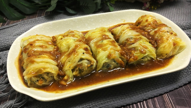 金玉白菜卷,起锅放油,放入切碎的蒜蓉小火爆香,再倒入蒸白菜多出的水,加入生抽、蚝油、生粉勾芡,倒在白菜卷上就完成啦