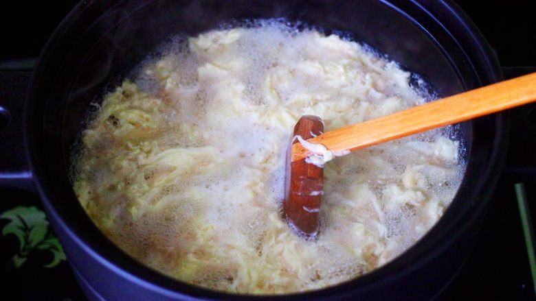 银杏冰糖酒酿鸡蛋羹,大火煮沸后,用勺子把鸡蛋花慢慢打散。