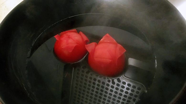 番茄烩金针菇,锅中水烧开后关火放入西红柿,转动,保证每个面都过水,这样皮就很容易去掉了。
