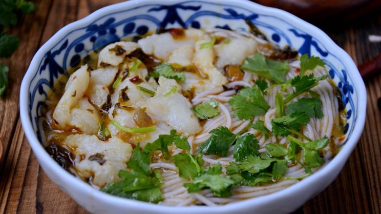 酸菜鱼米线,米线铺下面,酸菜鱼铺上面,撒上香菜碎。