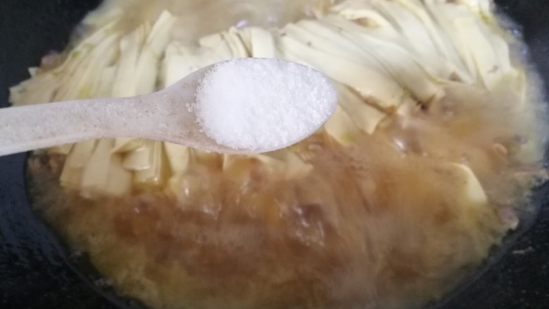 家常肉炖干豆腐,烧炖一会儿汤汁收至一半时,放一小勺盐。