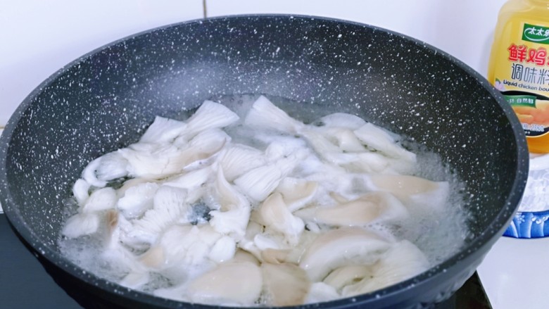 比肉还好吃的鸡汁炒平菇,锅中加入纯净水大火烧开,下入撕小块的平菇,大火焯水2分钟,捞出用冷水冲洗后挤干水分。