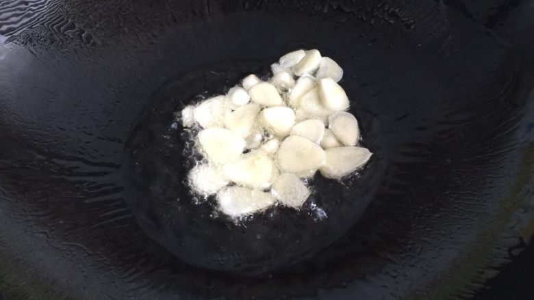 回锅肉,锅内放油烧热,放入蒜片爆香